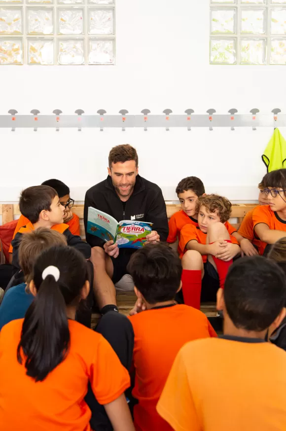 Mestre de l'escola Jesuïtes Poble Sec envoltat d'alumnes atents