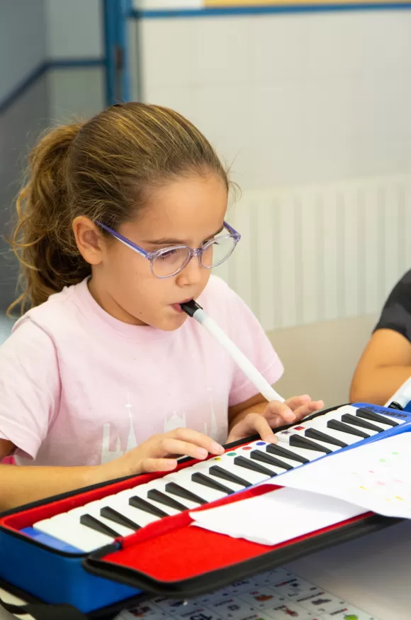 Alumna de primaria de l'escola Jesuites Poble-sec amb un piano