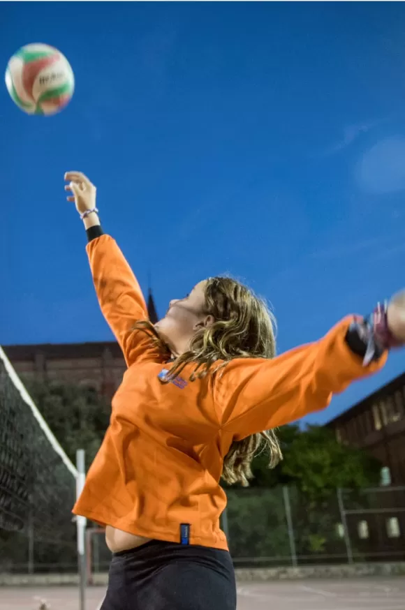 Noia sacant la pilota de voleibol