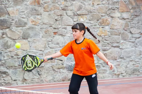 Alumna jugant a tenis a l'extraescolar de l'escola Jesuites Poble-sec