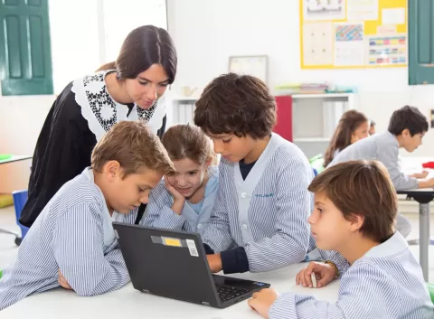 Alumnes i docent de primaria de l'escola Jesuites Sarria - Sant Ignasi amb l'ordinador