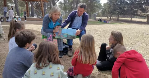 Alumnes de 1r de primària en l'activitat de conta-contes amb padrines i padrines realitzada al pati del Claver.