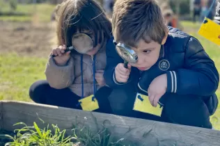 Nen i nena de P3 observant insectes en el taller educatiu de Pagesos per un Dia al Punt Eco