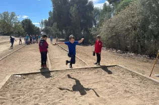 Nens i nenes participant en la prova de salt a la pista d'atletisme del Claver durant les Olimpíades de la PIN