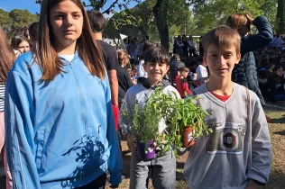 Alumnes amb les plantes de la celebració de la Pasqua, cuidades durant la Quaresma, per plantar al pati de l'escola