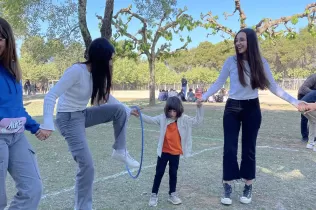 Alumnes fent jocs i activitats, agermanats grans i petits, i en comunitat al pati de l'escola per la celebració de la Quaresma