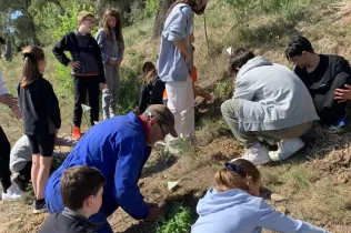 Alumnes grans i petits fent la plantada al pati de l'escola en la celebració de la Pasqua