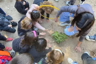 Alumnes grans i petits fent la plantada al pati de l'escola en la celebració de la Pasqua