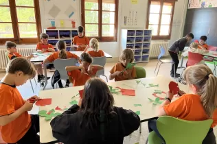 Alumnes de 3r de primària del Col·legi Claver fent les roses de Sant Jordi amb paper