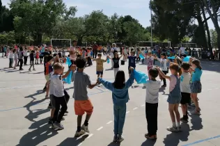 Infants de 1r i 2n de primària ballant sardanes al pati de l'escola en motiu de la celebració de Sant Jordi