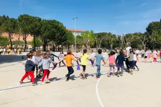 Infants de 1r i 2n de primària ballant sardanes al pati de l'escola en motiu de la celebració de Sant Jordi
