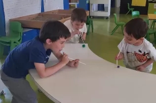 Nens i nenes de P4 fent experiments d'aire amb canyetes i boletes per treballar aquelles coses que existeixen però que no podem veure
