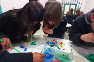 Nens i nenes de P5 fent experiments d'aire fent pintura bufant amb canyetes per treballar aquelles coses que existeixen però que no podem veure
