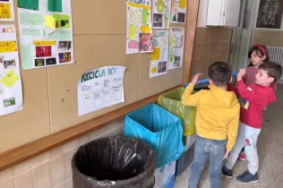 Nens i nenes de MOPI P5 identificant les diferents paperes que troben eals passadissos de l'escola per a poder fer reciclatge
