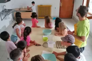 Nens i nenes de 2n de primària preparant flams al taller de cuina de la granja escola de La Manreana