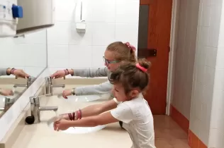 Alumnes de 2n de primària rentant-se les mans amb l'aixeta oberta com a mostra de un mal ús i malbaratament de l'aigua