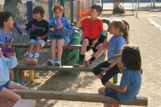 Alumnes de 2n de primària amb ampolles d'aigua parlant del malbaratament de l'aigua quan no ens bevem tota l'aigua que ens posem a l'ampolla o al got 