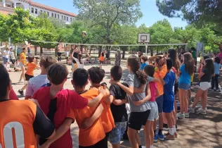 Alumnes de la NEI animant els companys i companyes en el partit de voleibol contra educadors i educadores de l'escola