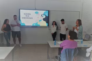 Foto d'arxiu dels quatre membres de l'equip guanyador "Alegra tus emociones" fent l'exposició a l'escola.