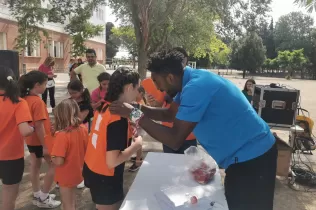 Alumnes de l'activitat paraescolar de voleibol de MENOF de Jesuïtes Lleida rebent les seves medalles de la mà de l'entrenador Eddy Herrera el dia de la festa de cloenda 2022-23