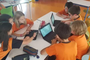 Grup d'alumnes de 5è de primària treballant en equip fent recerca sobre la sang en el projecte Ho Portem a la Sang