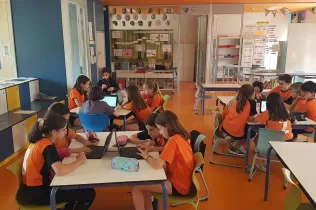 Grup d'alumnes de 5è de primària treballant en equip fent recerca sobre la sang en el projecte Ho Portem a la Sang