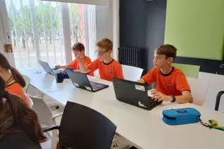 Grup d'alumnes de 5è de primària treballant en equip fent recerca sobre la sang en el projecte Ho Portem a la Sang