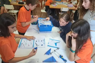 Alumnes de la NEI, de 6è primària i de 2n ESO, treballant col·laborativament per construir una caravel·la amb Lego Education