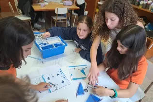 Alumnes de la NEI, de 6è primària i de 2n ESO, treballant col·laborativament per construir una caravel·la amb Lego Education