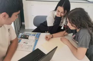Alumnes a l'aula en la matèria d'anglès treballant en equip un text escrit.