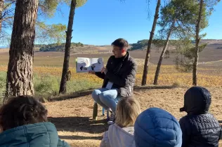 Famílies i infants a la cerca del Tió al bosc del Claver i trobant un contacontes nadalenc pel camí