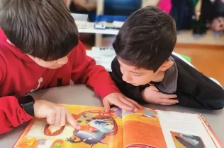 Apadrinament lector: Un alumne de 6è de primària fent de padrí lector d'un alumne de 1r de primària