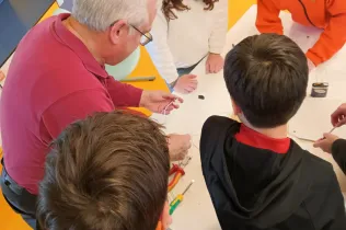 Alumnes de 6è de Primària-NEI treballant amb l'Enric Quinquilla, educador de l'escola del PAS, tcol·laborant amb l'alumnat en el marc del projecte Codi Energia