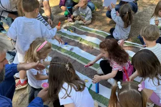 Famílies participant del Taller Natura al bosc del Claver amb els seus fills i filles de fins 3 anys