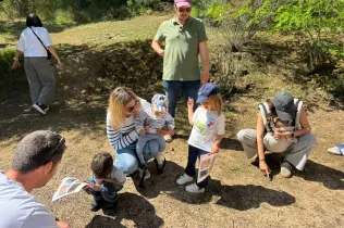 Famílies participant del Taller Natura al bosc del Claver amb els seus fills i filles de fins 3 anys