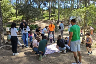 Famílies participant del Taller Natura al bosc del Claver amb els seus fills i filles de fins 3 anys