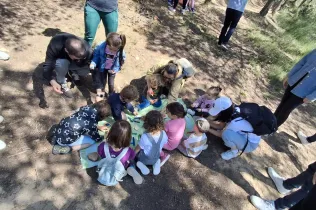 Famílies participant del Taller Natura al bosc del Claver amb els seus fills i filles de fins 3 anys