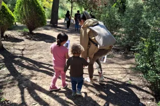 Famílies participant del Taller Natura al bosc del Claver amb els seus fills i filles de fins 3 anys