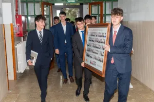 Alumnes portant l'Orla al passadís de l'escola per ser penjada junt amb les orles de generacions anteriors.