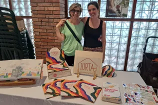 Membres de l'Associació Iurta en el mostrador de venda d'articles sobre el projecte Desplaçades