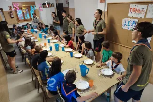 Alumnes de 3r de Primària beneint la taula abans de sopar a la casa de Senet.