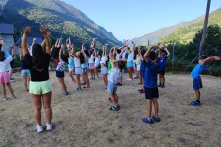 Alumnes de 3r de Primària acabats de llevar-se, fent ioga i agraint el dia que tenen per davant. 