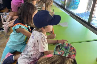 Alumnes de 1r i 2n de primària de Jesuïtes Lleida a la casa de VIlaller, escrivint cartes de comiat després d'uns dies de colònies. 