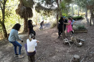 Docents d'infantil i primària al bosc de l'escola en sessions de modelatge d'escola de bosc amb Maria Castella en el marc del projecte Claver Natura