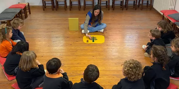 Alumnes a la capella escoltant una passatge de l'evangeli amb el Bagul Magis basat en la metodologia Montesori