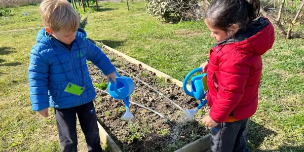 Infants de P3 regant l'hort al taller educatiu Pagesos per un Dia al Punt Eco