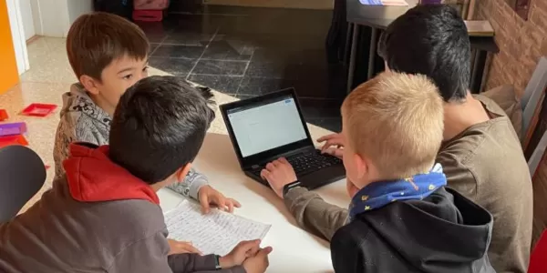 Alumnes de 2n de primària acompanyats per un alumne de 4t ESO-TQE fent treball col·laboratiu per digital·litzar els contes que prèviament havien escrit els més petits.