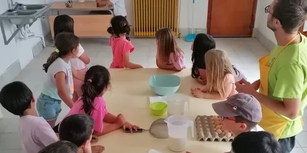 Nens i nenes de 2n de Primària preparats per fer flams en el taller de cuina de la granja escola La Manreana