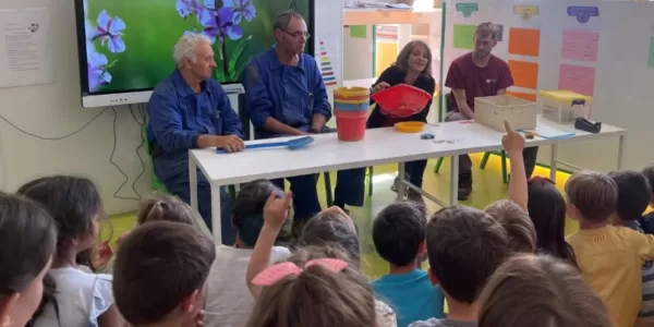 Alumnes de MOPI P5 escoltant les explicacions dels membres de l'equip de Manteniment i Serveis sobre les seves tasques a l'escola i la importància d'aquestes per la cura de la casa comuna, el medi ambient, i la sostenibilitat.