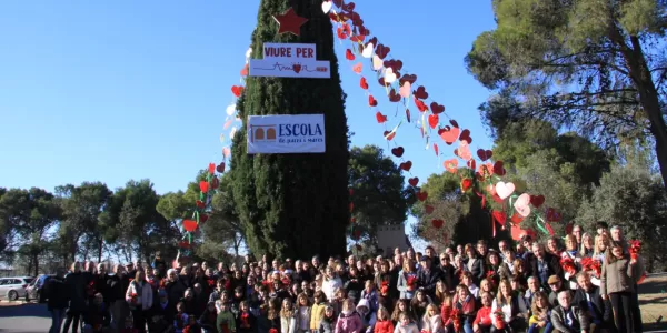 Foto en família de l'arbre de l'Escola de Pares i Mares del Claver a l'entrada de l'escola